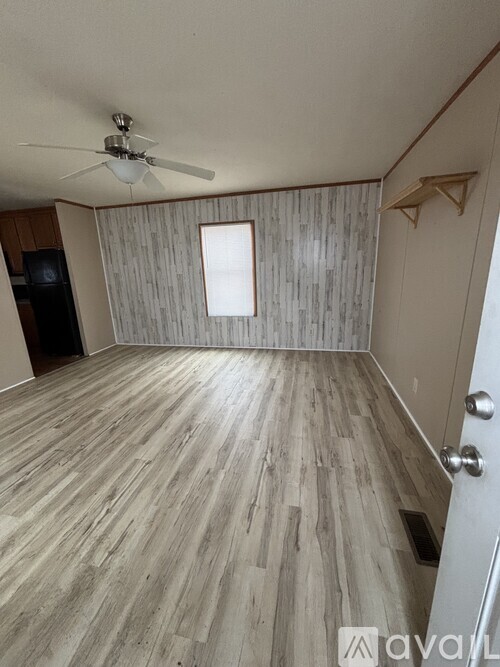 A room with wooden flooring and a ceiling fan.