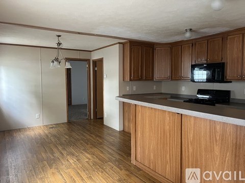 A kitchen with wooden cabinets and a black microwave.