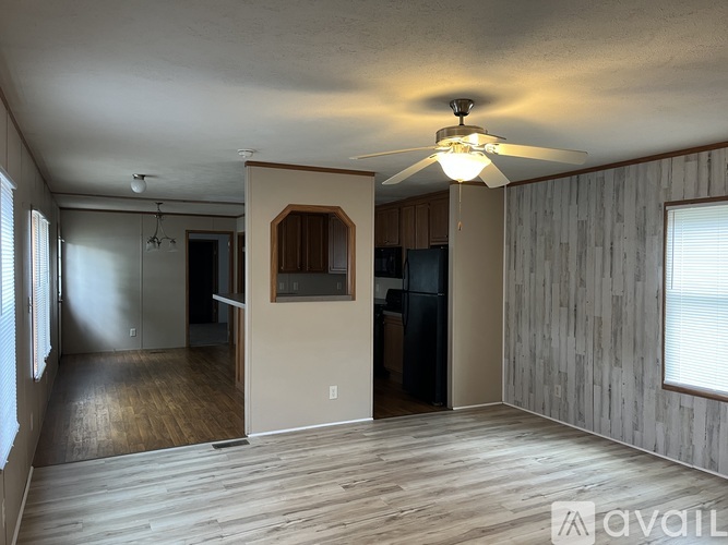 A spacious room with wooden flooring and a ceiling fan.