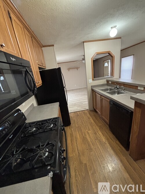 A kitchen with black appliances and wooden cabinets.