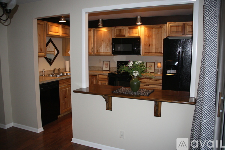A kitchen with wooden cabinets and a black refrigerator.