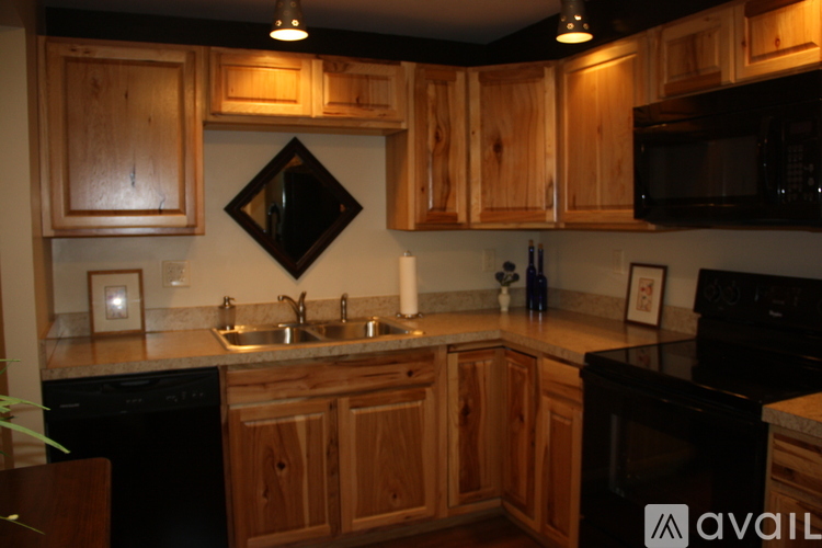 A kitchen with wooden cabinets and black appliances.