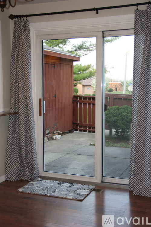 A room with a sliding glass door leading to a backyard.