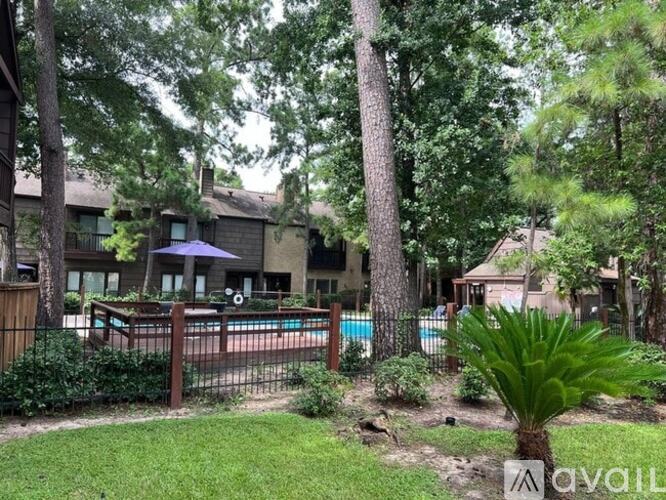 A pool surrounded by a fence and trees.