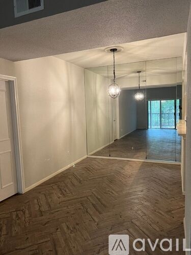 A hallway with a wooden floor and a white door.