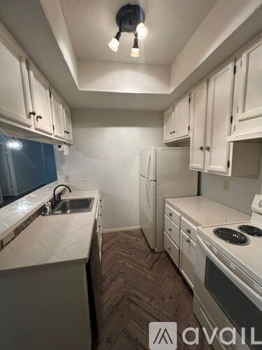 A kitchen with white cabinets and appliances.