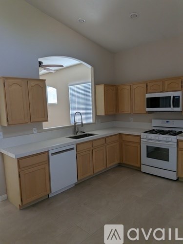 A kitchen with wooden cabinets and white appliances.