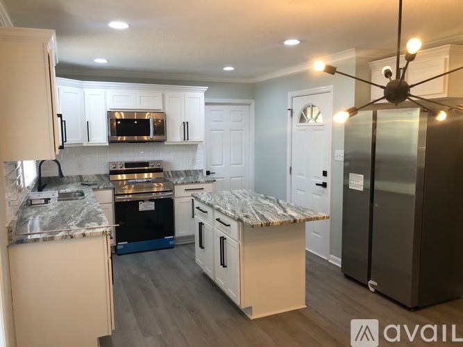 A kitchen with a marble countertop and a refrigerator.