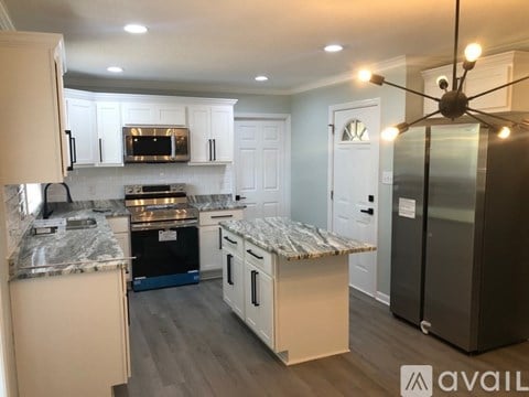 A kitchen with a marble countertop and a refrigerator.