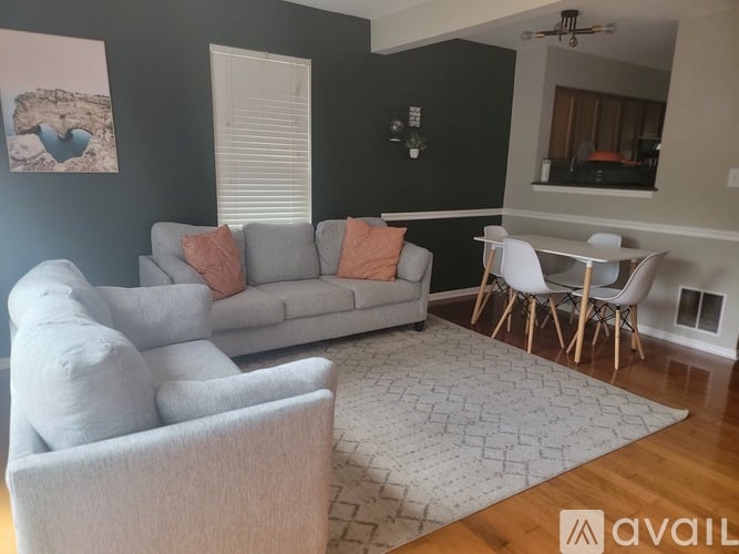 A living room with a grey couch and a white chair.