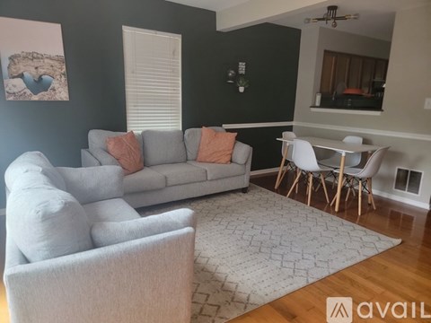 A living room with a grey couch and a white chair.