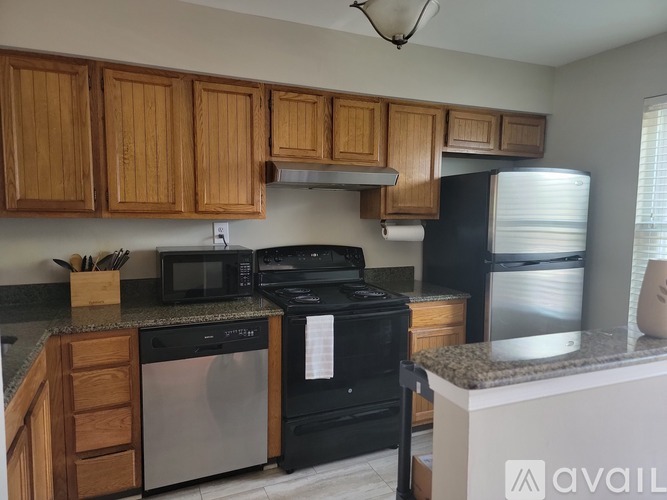 A kitchen with wooden cabinets and black appliances.