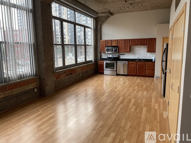 A kitchen with wooden floors and a window overlooking a cityscape.