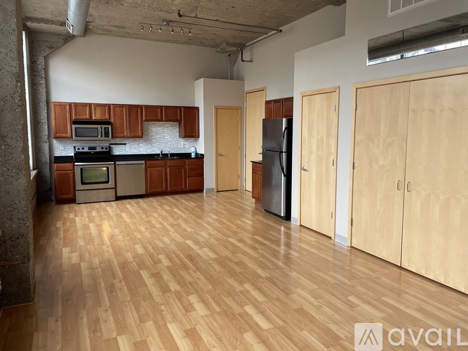 A kitchen with wooden floors and cabinets.