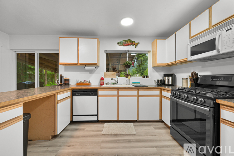 A kitchen with white cabinets and a black stove top oven.