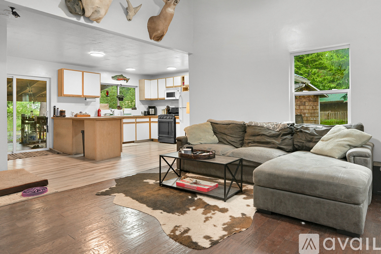 A living room with a grey couch and a cowhide rug.