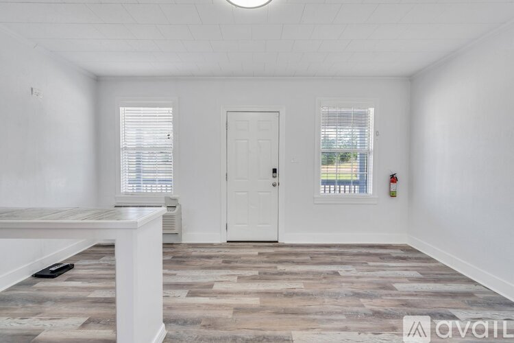 A room with a wooden floor and a white door.