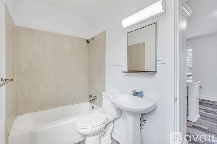 A white bathroom with a toilet, sink, and bathtub.