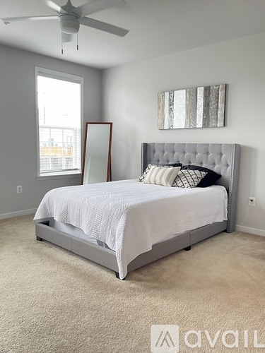 A bedroom with a large bed and a ceiling fan.