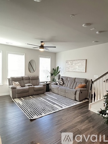 A living room with a grey sofa and a striped rug.