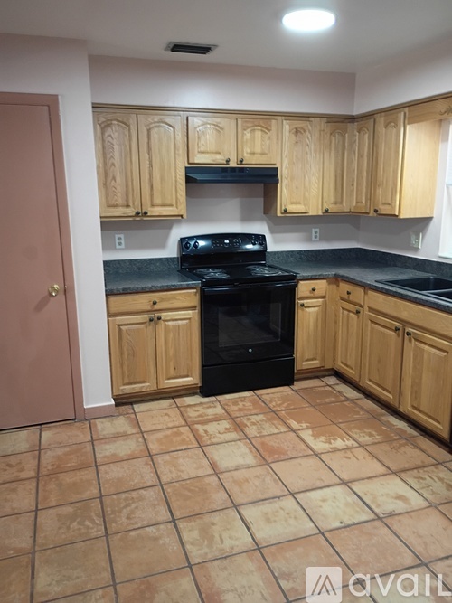 A kitchen with wooden cabinets and a black stove top oven.