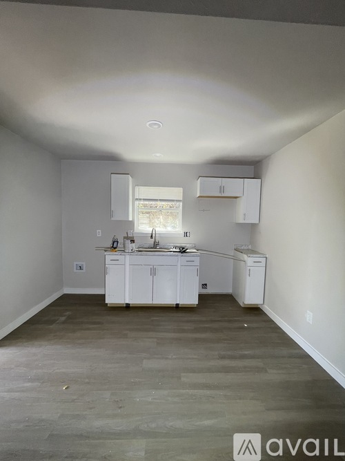 A kitchen with white cabinets and a window.