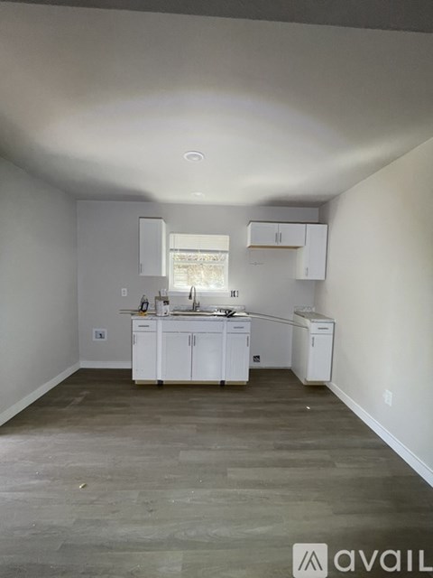 A kitchen with white cabinets and a window.
