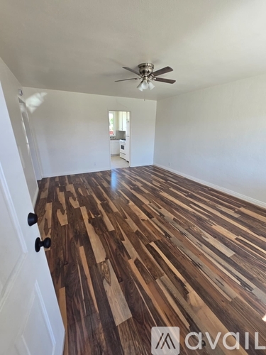 A room with wooden flooring and a ceiling fan.
