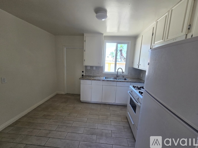 A kitchen with white appliances and cabinets.