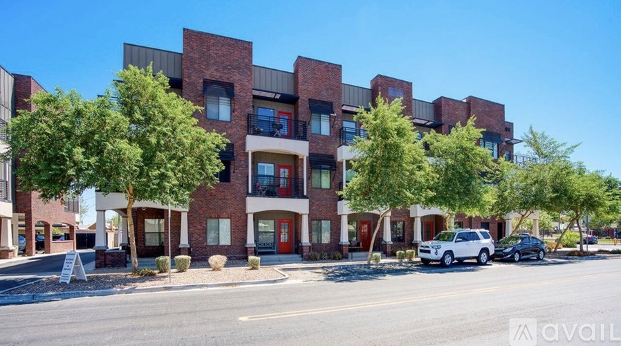 A modern apartment building with cars parked in front.