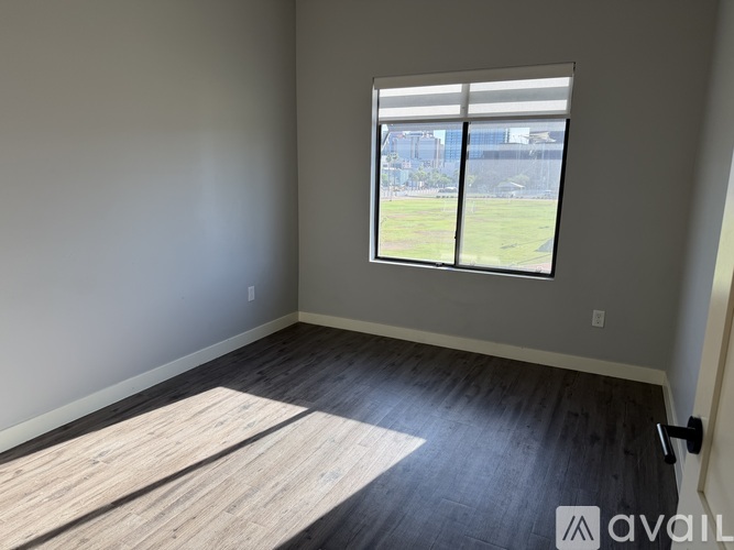 A room with a large window and wooden flooring.