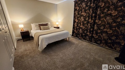 A bedroom with two beds and two lamps.