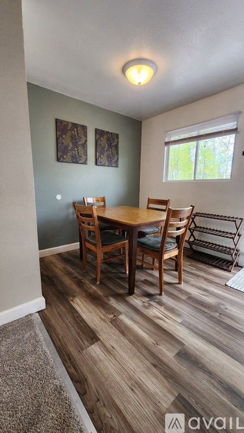 A dining room with a wooden table and chairs.