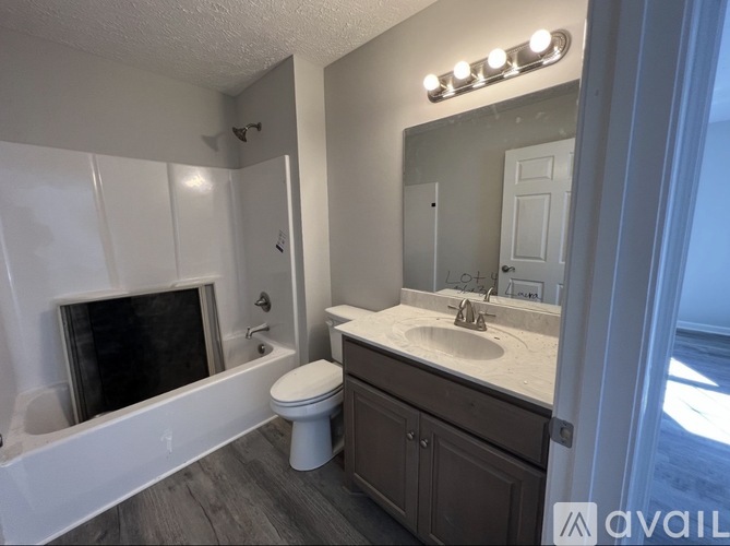 A bathroom with a white tub, toilet, and sink.