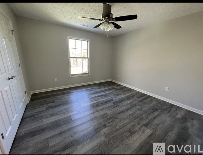 A room with a ceiling fan and a window.