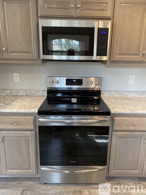 A kitchen with a stove top oven and microwave above it.