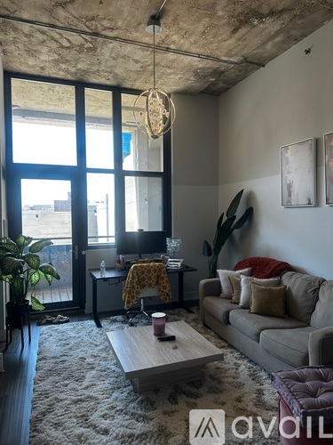 A living room with a couch, a coffee table, and a large window.