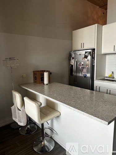A kitchen with a white counter and a fridge.