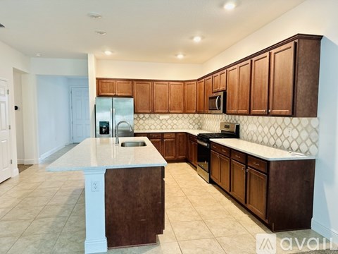A kitchen with brown cabinets and a white island.