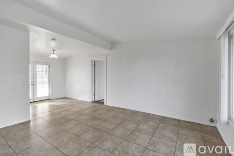 A room with tiled flooring and a window with blinds.