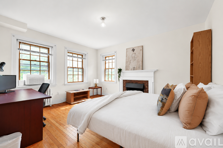 A bedroom with a large bed and a fireplace.