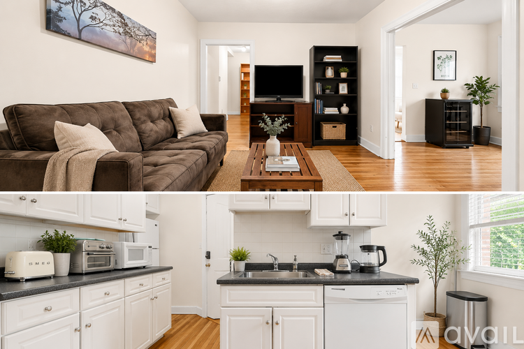 A living room with a brown couch and a kitchen with white cabinets.