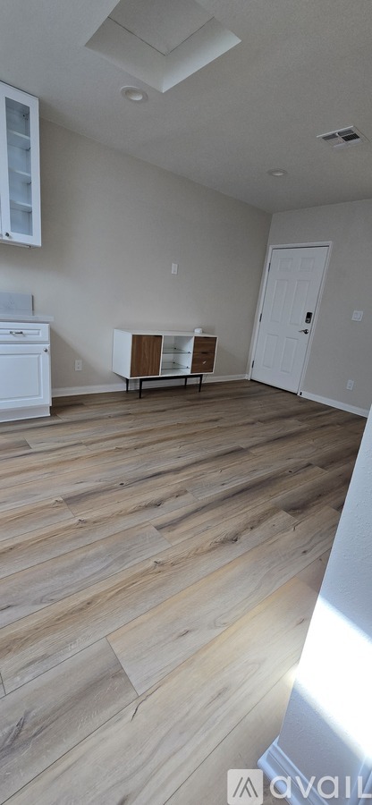 A room with wooden flooring and a white door.
