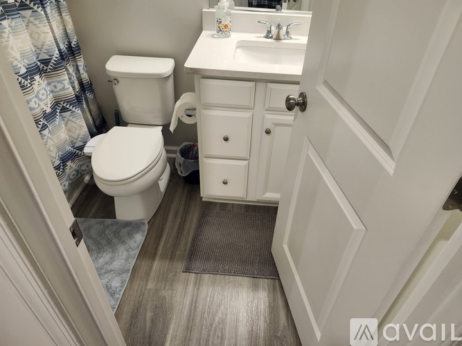 A small bathroom with a toilet, sink, and a door.
