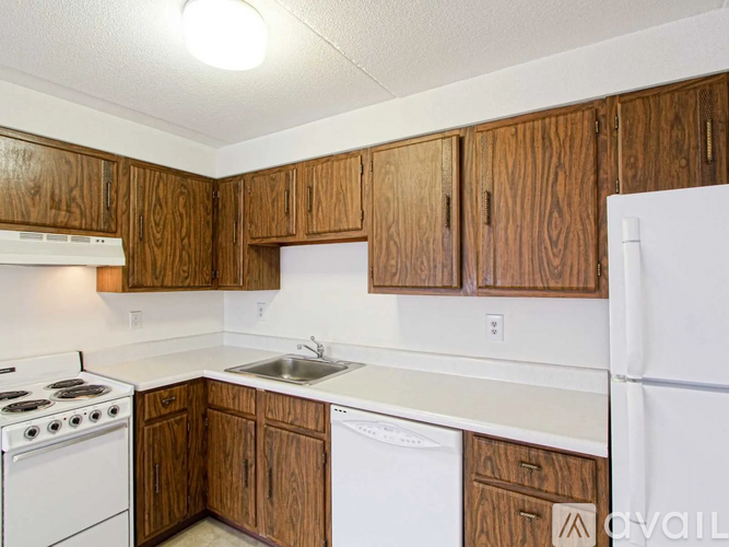 A kitchen with wooden cabinets and white appliances.