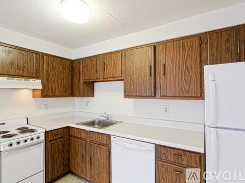 A kitchen with wooden cabinets and white appliances.