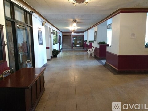 A long hallway with a brown floor and white walls.
