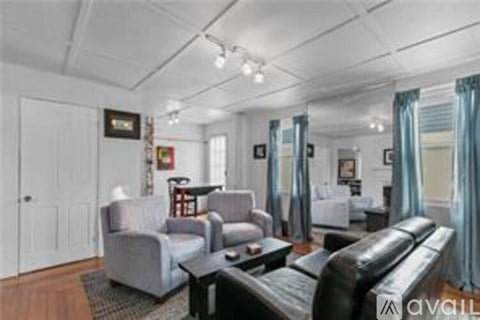 A living room with a grey couch, a black coffee table, and a white door.