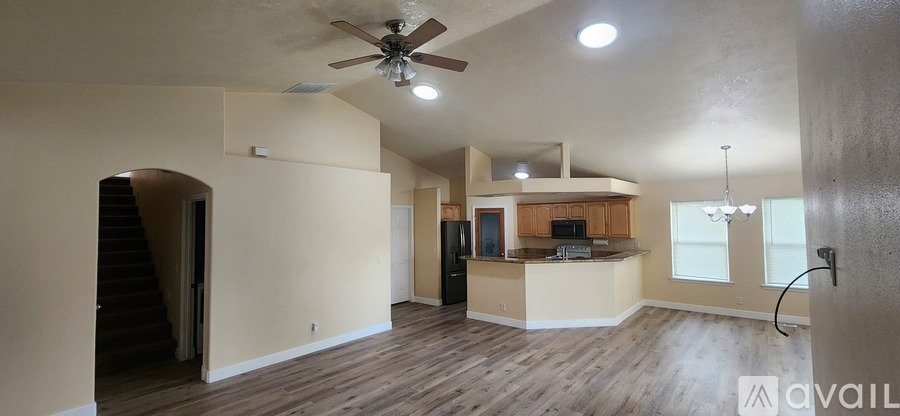 A spacious living room with a staircase leading to the upper floor.