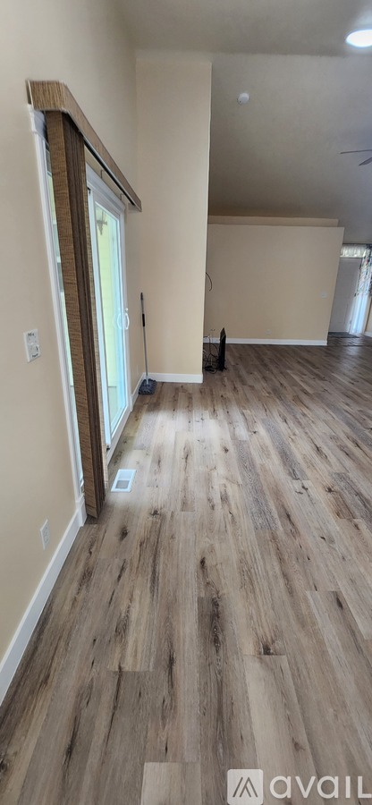A room with wooden flooring and a window.